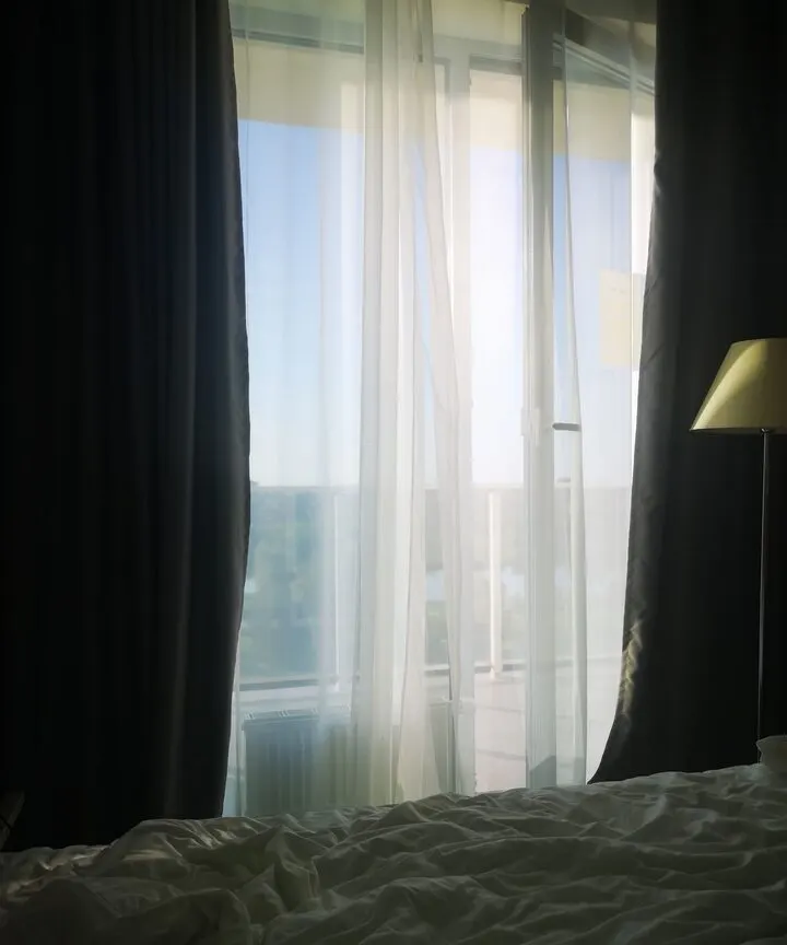 Akşam ışığında tül perdeli otel odası